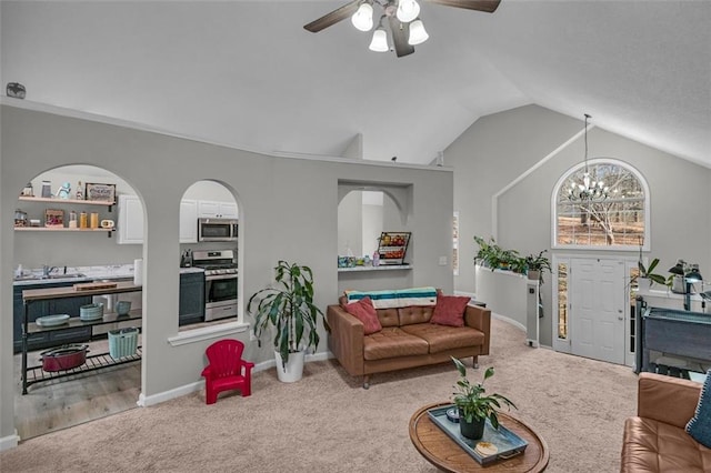 living room with ceiling fan with notable chandelier, vaulted ceiling, and carpet