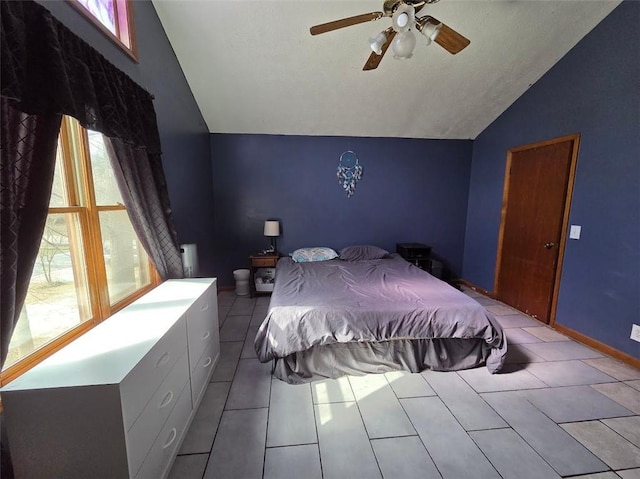 tiled bedroom featuring vaulted ceiling, baseboards, and ceiling fan