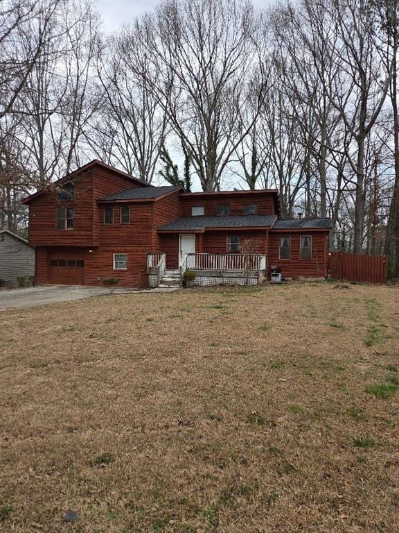 view of front of property with a garage, a front yard, and fence