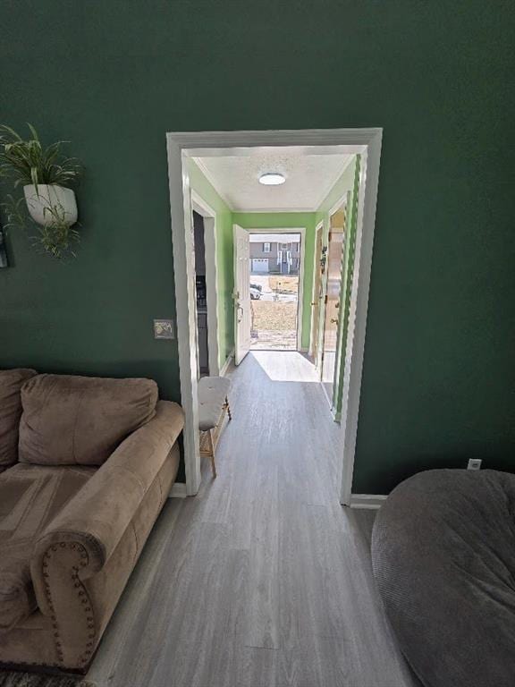 hallway featuring baseboards and wood finished floors