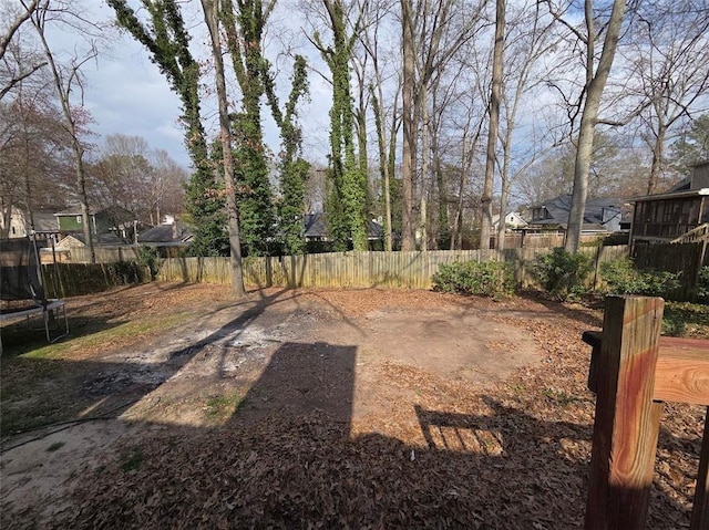 view of yard with fence private yard and a trampoline