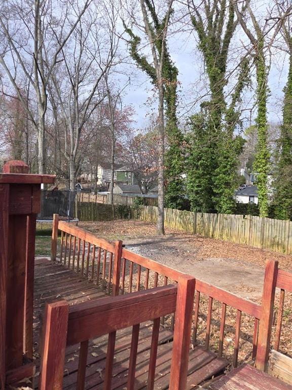 wooden terrace featuring a trampoline and a fenced backyard