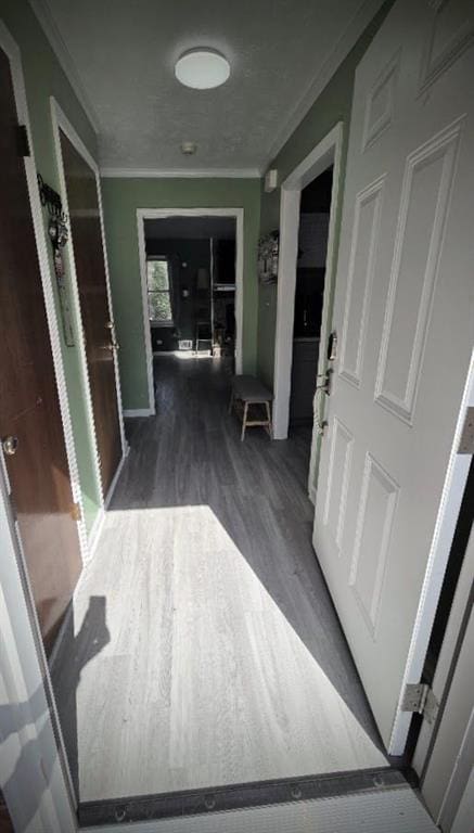 hallway featuring ornamental molding and wood finished floors