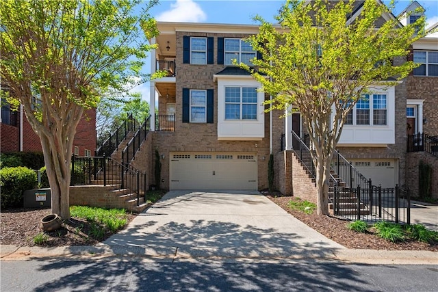 townhome / multi-family property featuring stairs, an attached garage, and concrete driveway