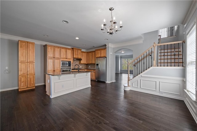 kitchen with stainless steel appliances, arched walkways, dark countertops, a chandelier, and ornamental molding
