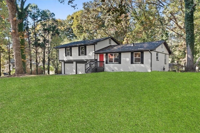 tri-level home featuring an attached garage and a front lawn