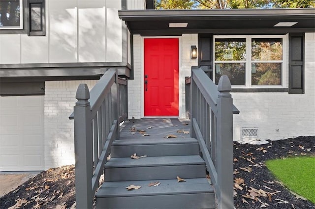 entrance to property featuring brick siding and an attached garage