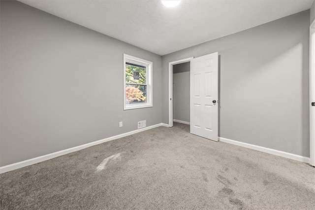 unfurnished bedroom with visible vents, baseboards, and carpet