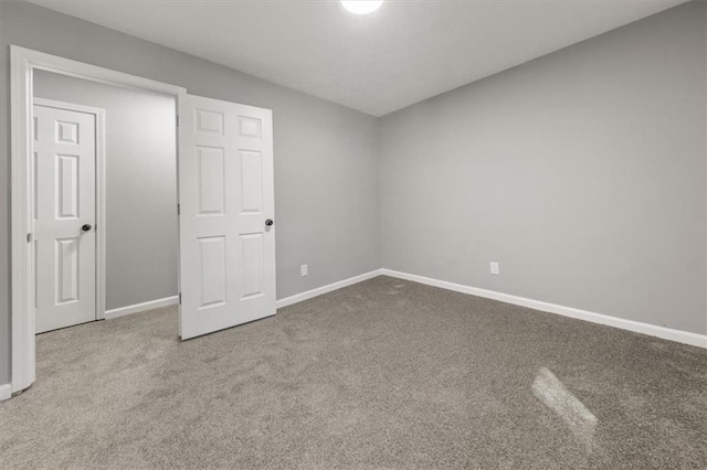 unfurnished bedroom featuring carpet flooring and baseboards