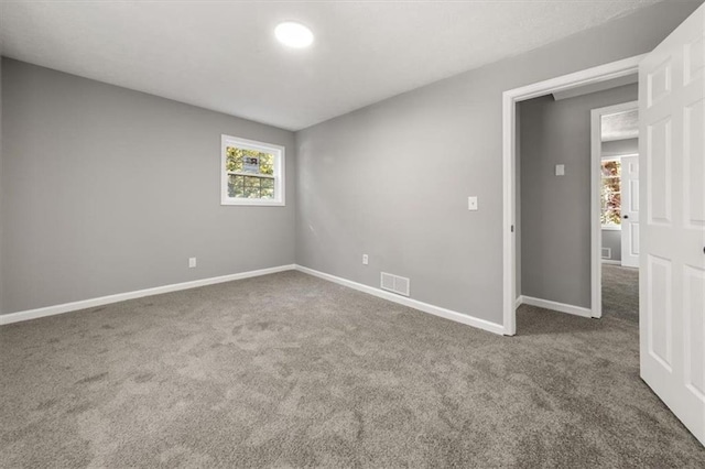 unfurnished room featuring carpet floors, baseboards, and visible vents