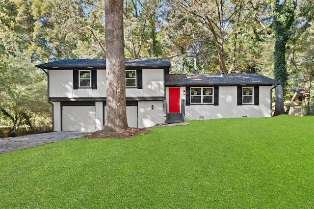 tri-level home featuring a front yard, entry steps, an attached garage, and concrete driveway