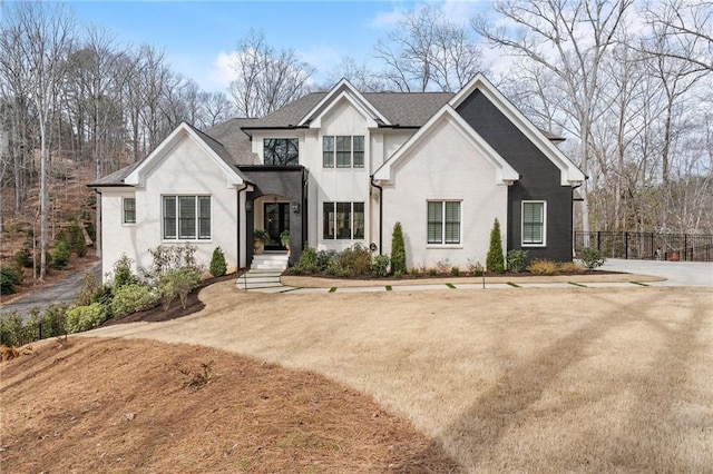 view of front of property with a shingled roof and fence