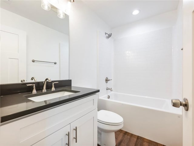 bathroom with vanity, shower / washtub combination, wood finished floors, and toilet