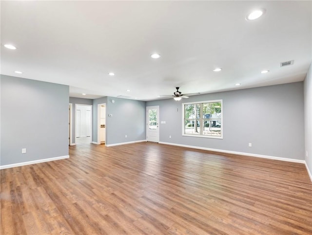 empty room featuring light wood finished floors, baseboards, visible vents, and recessed lighting