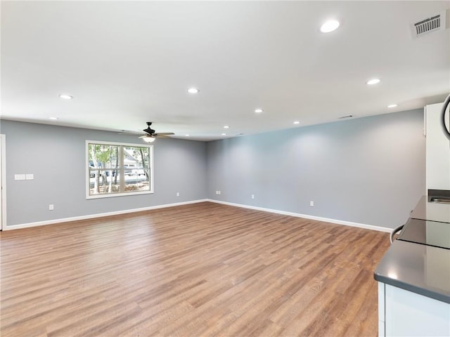 unfurnished living room with recessed lighting, baseboards, visible vents, and light wood finished floors