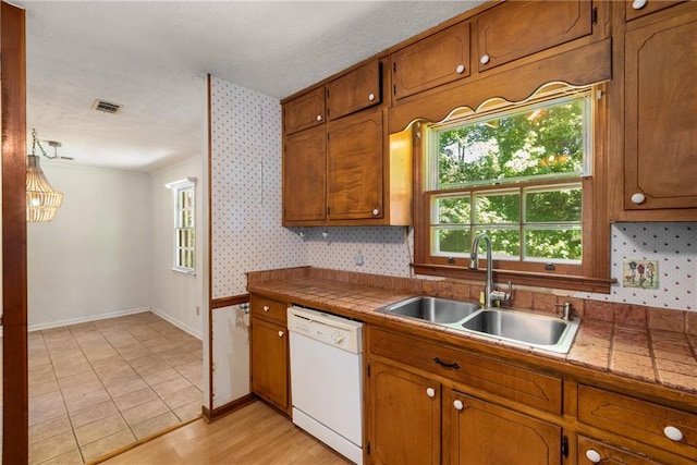 2617 Laurel Woods Ln SE, Conyers, GA 30094 - kitchen with dishwasher, brown cabinets, and a textured ceiling