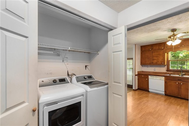 2617 Laurel Woods Ln SE, Conyers, GA 30094 - laundry room featuring washing machine and dryer, light wood-style flooring, ceiling fan, and a textured ceiling