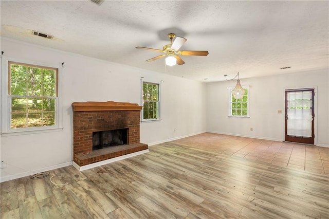 2617 Laurel Woods Ln SE, Conyers, GA 30094 - unfurnished living room with a textured ceiling, light wood finished floors, healthy amount of natural light, and ceiling fan