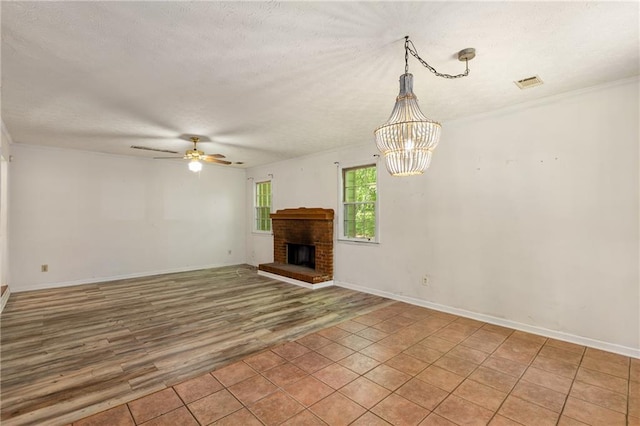 2617 Laurel Woods Ln SE, Conyers, GA 30094 - unfurnished living room featuring a textured ceiling, ceiling fan, light wood-style floors, a chandelier, and a brick fireplace