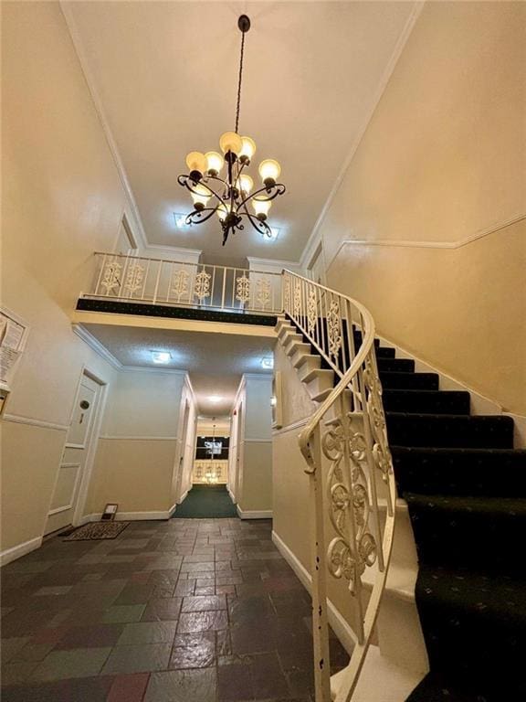 6851 Roswell Rd Unit D33, Atlanta, GA 30328 - stairs with crown molding, a high ceiling, baseboards, a chandelier, and stone tile flooring