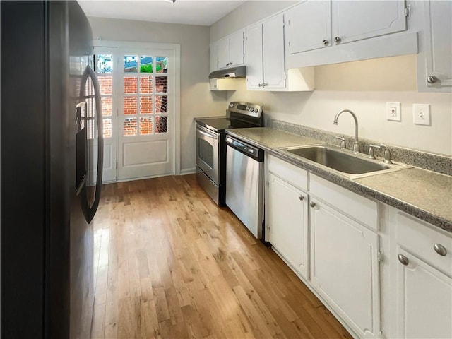 kitchen with stainless steel appliances, white cabinetry, sink, and light wood-type flooring