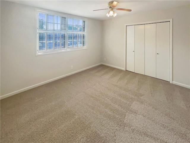 unfurnished bedroom featuring carpet floors, ceiling fan, and a closet