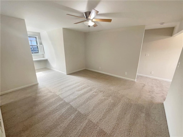 empty room featuring light colored carpet and ceiling fan