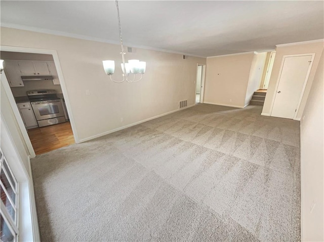 unfurnished room featuring ornamental molding, carpet flooring, and an inviting chandelier