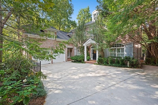 view of property hidden behind natural elements with a garage