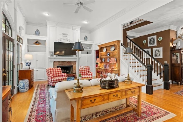 living room with hardwood / wood-style flooring, built in shelves, ceiling fan, and a fireplace