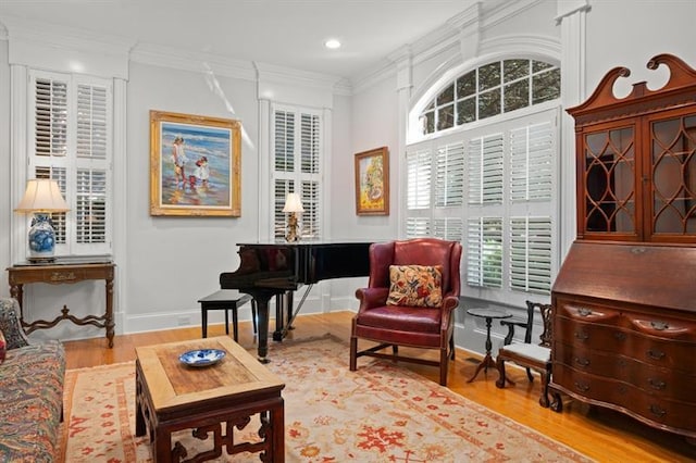 sitting room with crown molding and hardwood / wood-style flooring