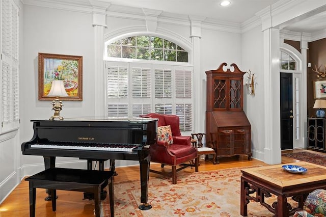 living area with light hardwood / wood-style flooring and crown molding