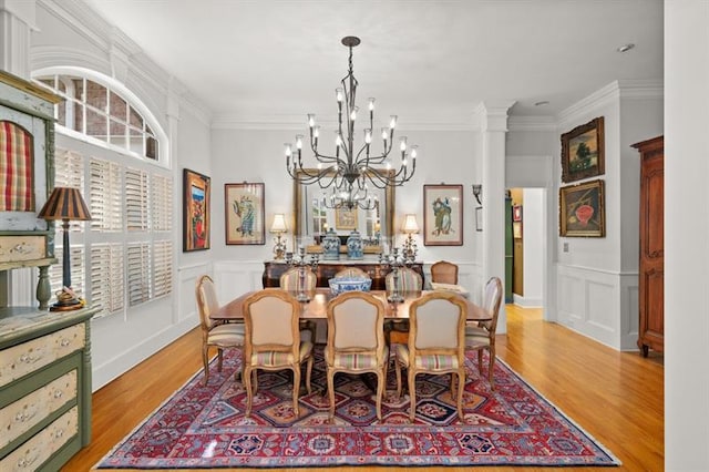 dining area featuring ornate columns, crown molding, and light hardwood / wood-style flooring