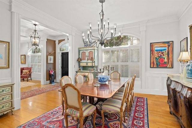 dining space with light hardwood / wood-style floors and ornamental molding