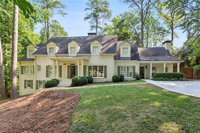 new england style home with a front lawn and a chimney