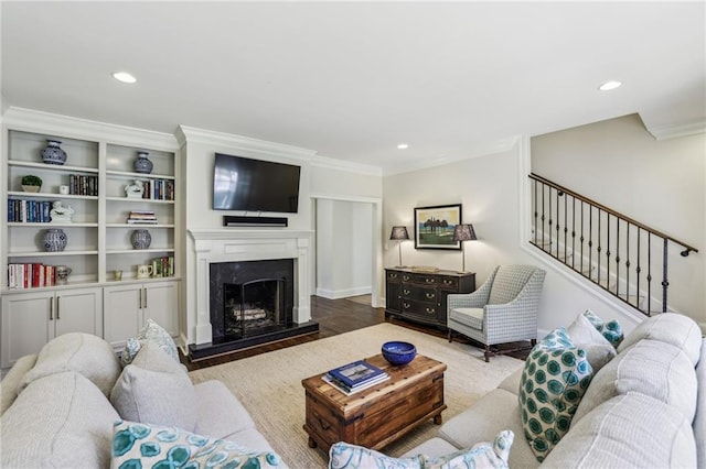 living room with stairs, a fireplace, crown molding, and recessed lighting