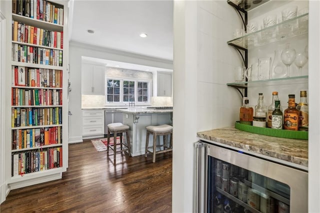 bar with tasteful backsplash, dark wood-style floors, wine cooler, a bar, and stainless steel dishwasher