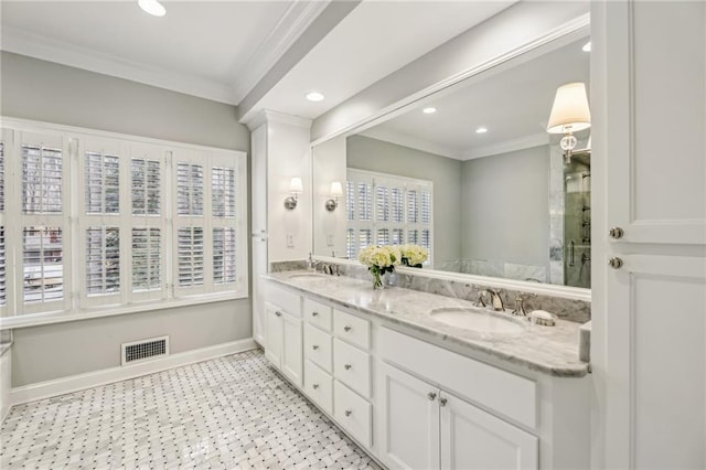 full bath with a sink, visible vents, baseboards, double vanity, and crown molding