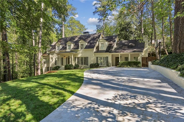 new england style home featuring driveway and a front yard