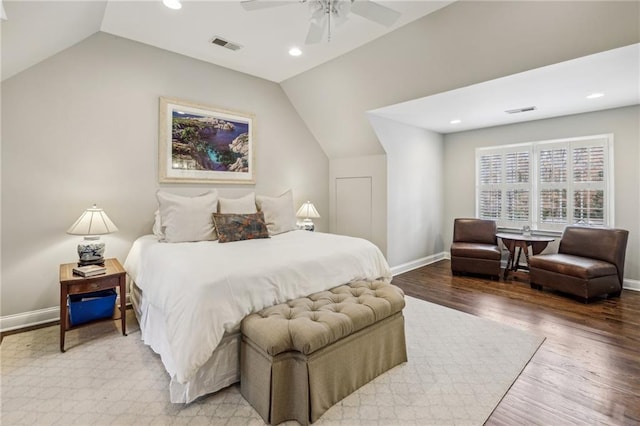 bedroom with visible vents, vaulted ceiling, baseboards, and wood finished floors