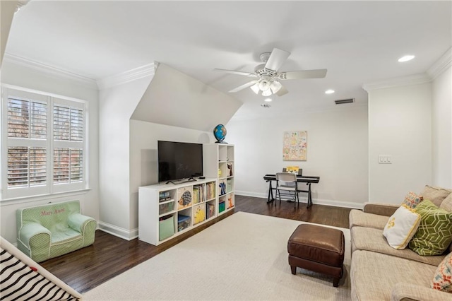 living room featuring a ceiling fan, crown molding, baseboards, and wood finished floors