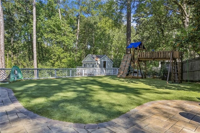 view of yard with a fenced backyard, a playground, and a patio