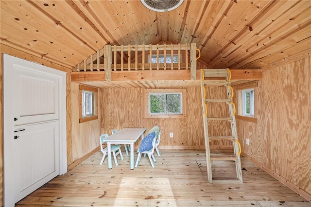 unfurnished dining area with wood ceiling, wood-type flooring, and wooden walls