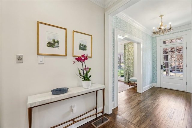 doorway featuring dark wood-style floors, visible vents, ornamental molding, and an inviting chandelier