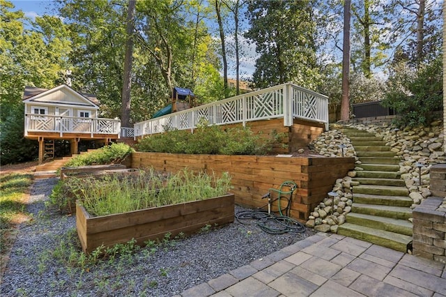 view of yard with a deck, stairway, and a garden