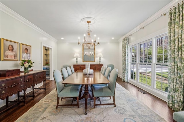 dining room with crown molding, visible vents, a notable chandelier, and wood finished floors