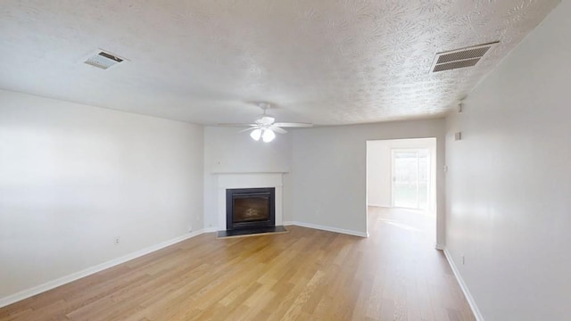 364 Springhaven Way, Lawrenceville, GA 30046 - unfurnished living room featuring light wood-type flooring, a ceiling fan, a fireplace with flush hearth, and a textured ceiling