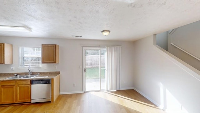 364 Springhaven Way, Lawrenceville, GA 30046 - kitchen with stainless steel dishwasher, light wood finished floors, brown cabinets, light countertops, and a textured ceiling