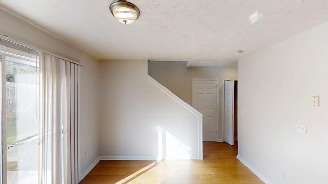 364 Springhaven Way, Lawrenceville, GA 30046 - spare room featuring light wood-style flooring, stairs, and a textured ceiling