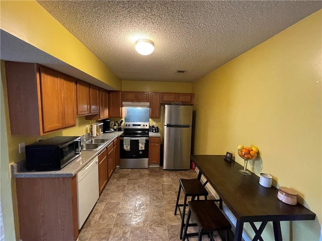 kitchen featuring sink, appliances with stainless steel finishes, and a textured ceiling